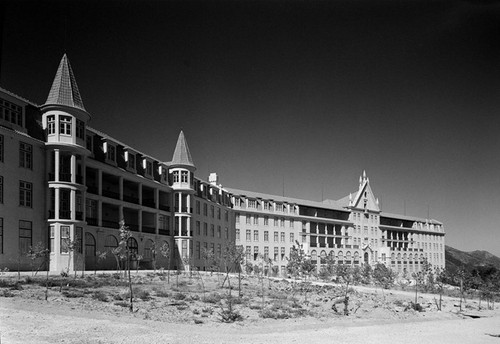 Spooky Place in Portugal. The image is in black and white. Shows a big abandoned building, with the sun lighting part of the façade.